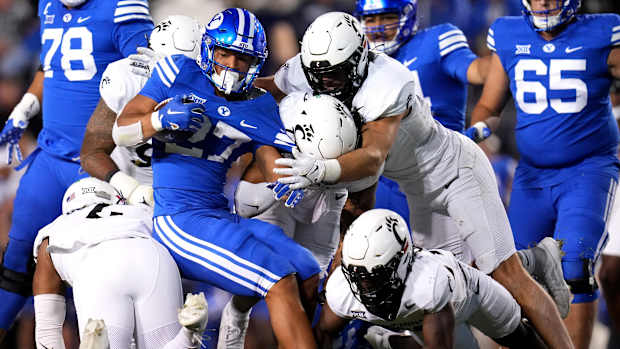 Brigham Young Cougars running back LJ Martin (27) is gang tackled by the Cincinnati Bearcats defense in the third quarter during a college football game between the Brigham Young Cougars and the Cincinnati Bearcats, Saturday, Sept. 30, 2023, at LaVell Edwards Stadium in Provo, Utah.